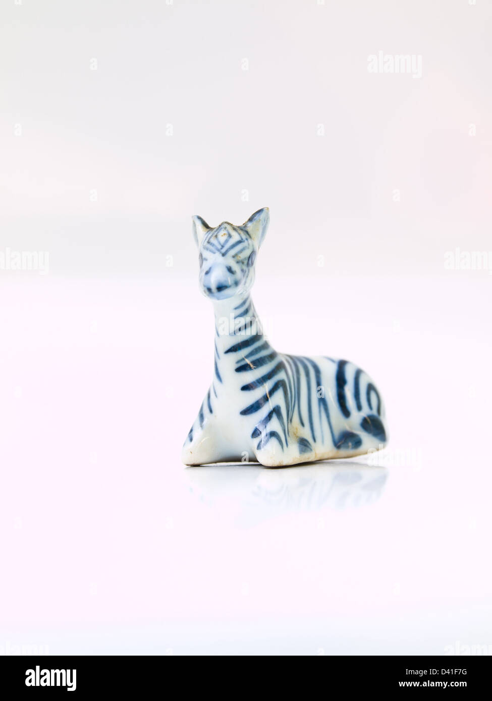Une poupée en céramique de light blue zebra isolé sur fond blanc en position assise Banque D'Images Une poupée en céramique de light blue zebra isolé sur fond blanc en position assise Banque D'Images