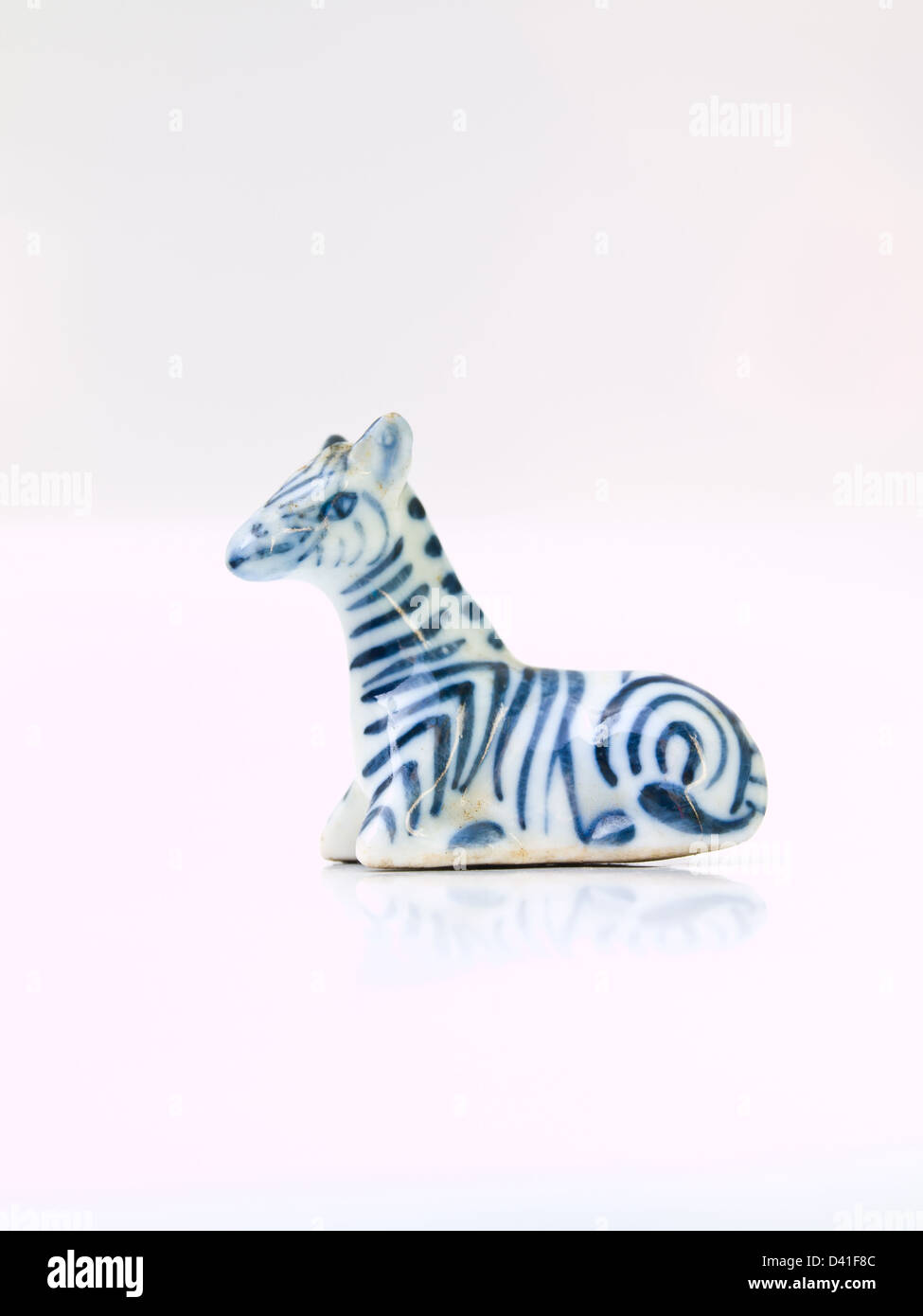 Une poupée en céramique de light blue zebra isolé sur fond blanc en position assise Banque D'Images Une poupée en céramique de light blue zebra isolé sur fond blanc en position assise Banque D'Images
