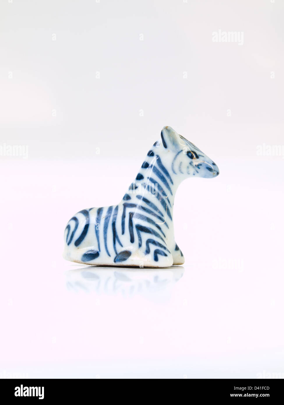 Une poupée en céramique de light blue zebra isolé sur fond blanc en position assise Banque D'Images Une poupée en céramique de light blue zebra isolé sur fond blanc en position assise Banque D'Images