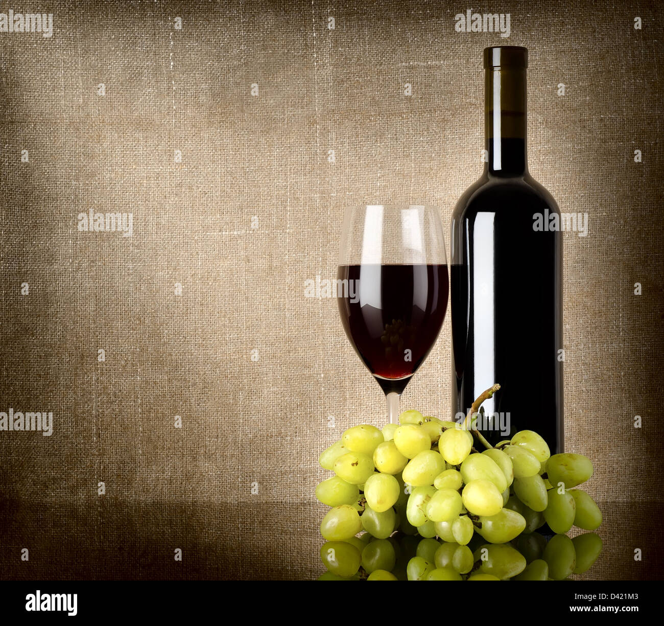 Bouteille de vin rouge et les raisins sur une toile de fond Banque D'Images