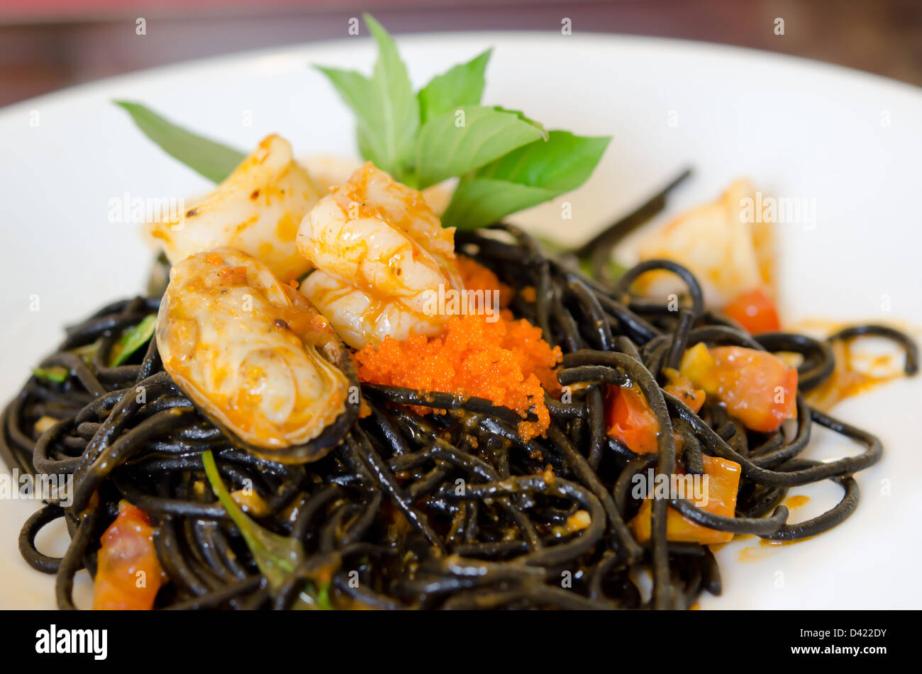 Spaghetti aux moules vert noir , des œufs de poisson et les crevettes sur un plat blanc Banque D'Images