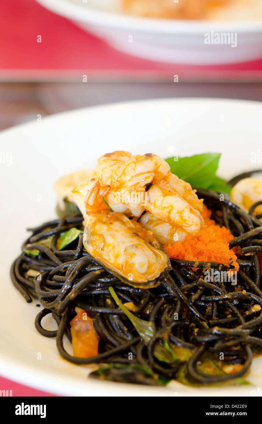 Spaghetti aux moules vert noir , des œufs de poisson et les crevettes on white plate Banque D'Images