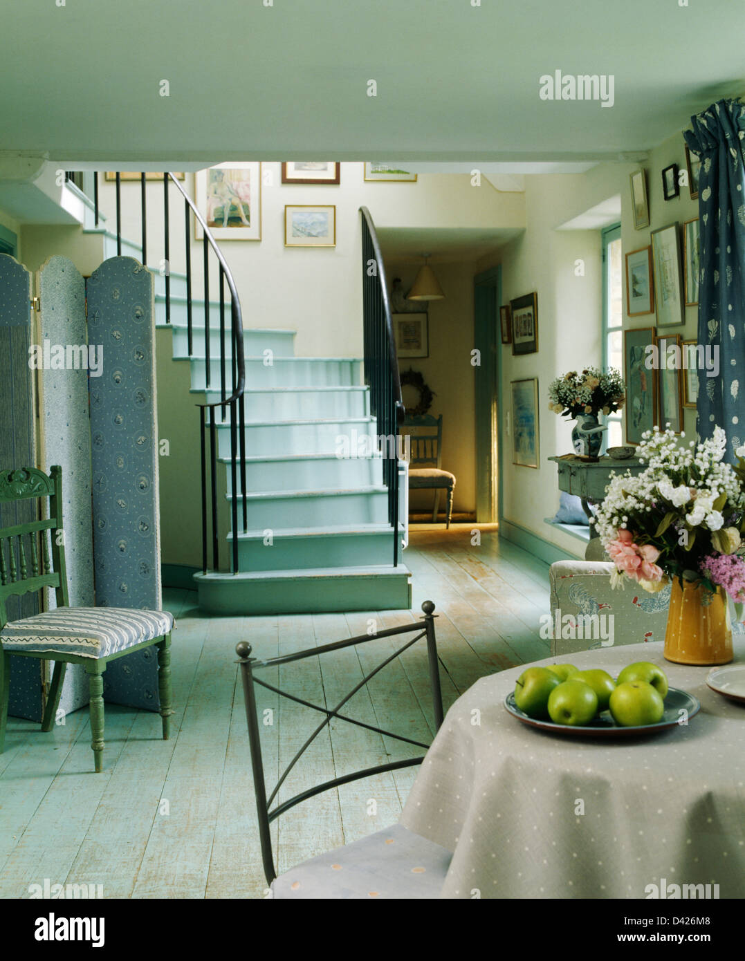 Escalier peint turquoise pâle et parquet en pays hall salle à manger avec table circulaire sur tissu beige Banque D'Images