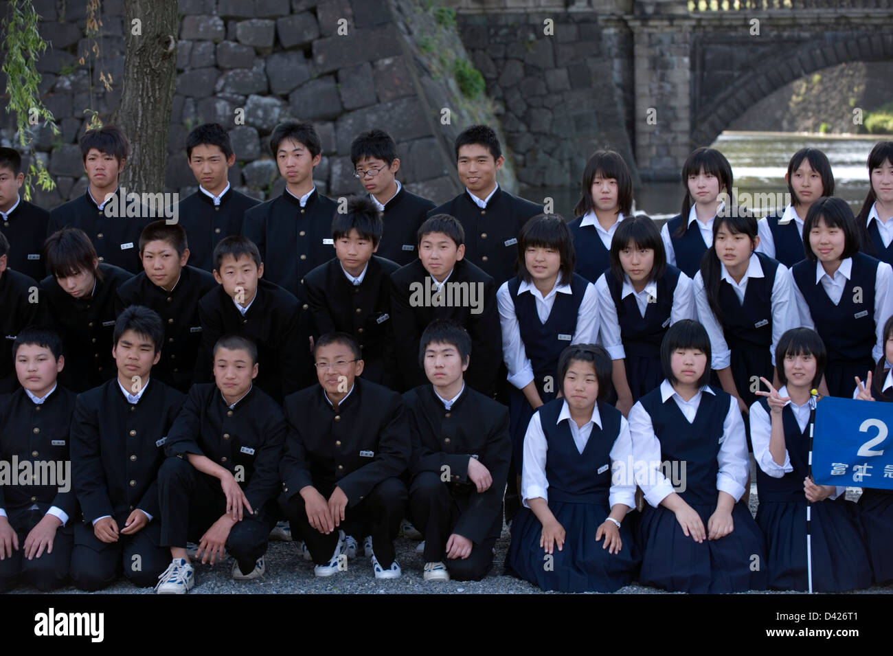 Groupe d'élèves du secondaire en uniforme qui pose pour la photo commémorative célèbre de Tokyo Nijubashi Imperial Palace Bridge Banque D'Images