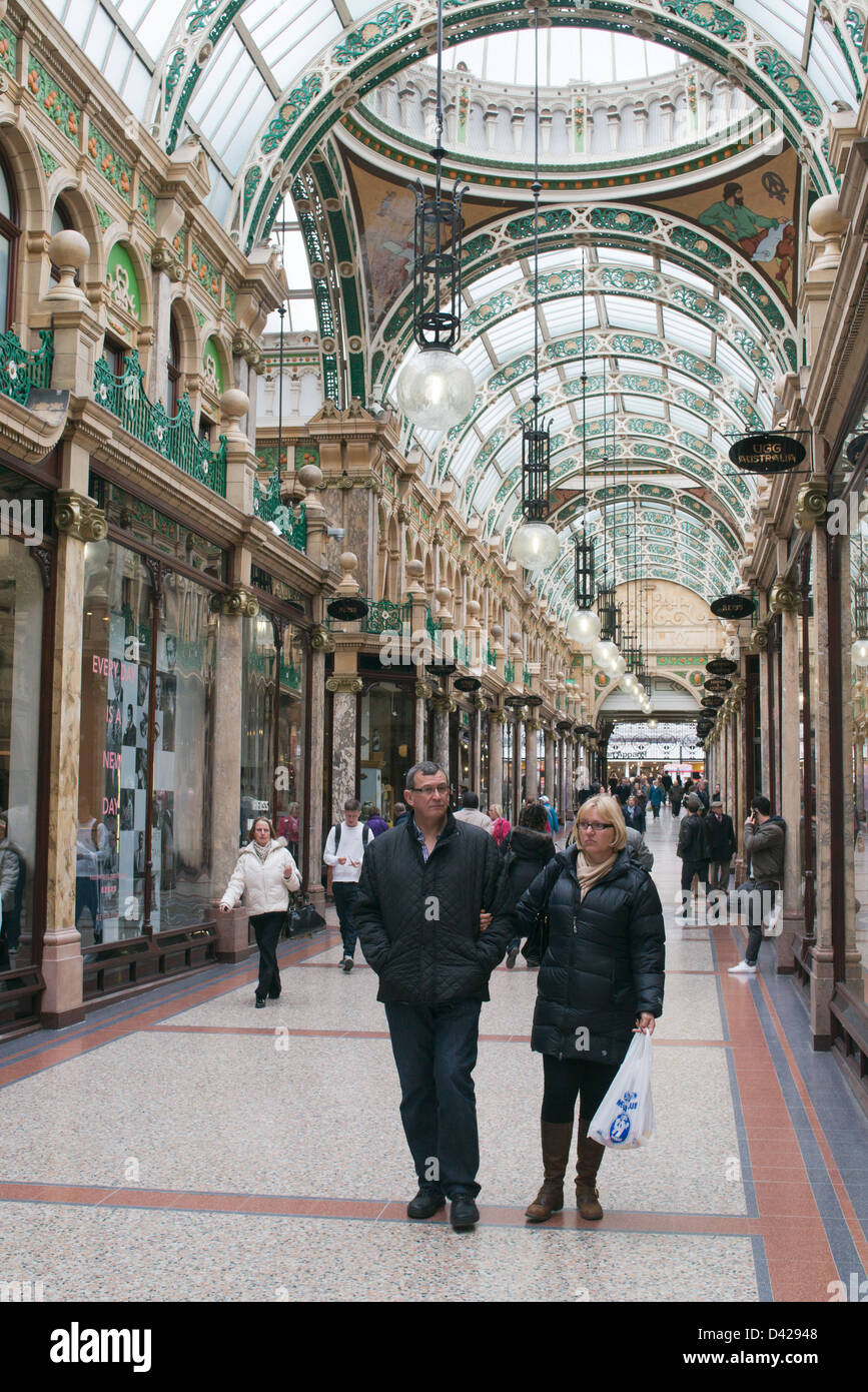 Couple walking through Arcade du comté de Leeds, Angleterre Banque D'Images
