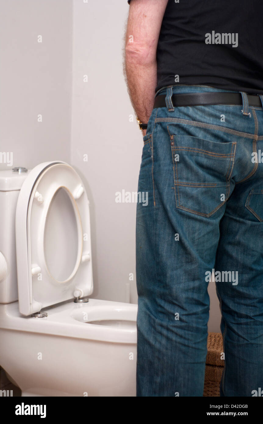 Homme debout en train d'uriner dans des toilettes avec le siège vers le  haut Photo Stock - Alamy
