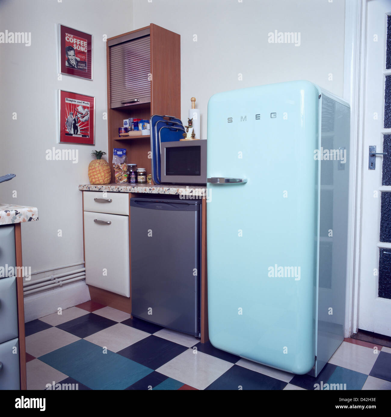 Bleu pâle et un réfrigérateur Smeg lave-vaisselle en acier inoxydable dans  la petite cuisine de style années 50 avec sol en damier Photo Stock - Alamy