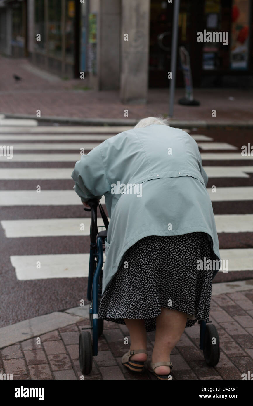 Kristinehamn, Suède, refoulées, vieille femme traverse un passage clouté Banque D'Images