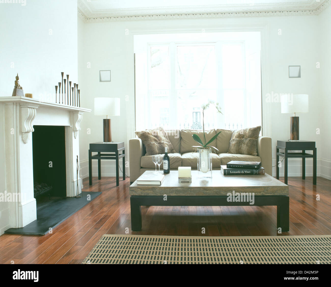 Table basse en marbre beige et blanc moderne canapé dans salon avec cheminée en marbre et parquet Banque D'Images