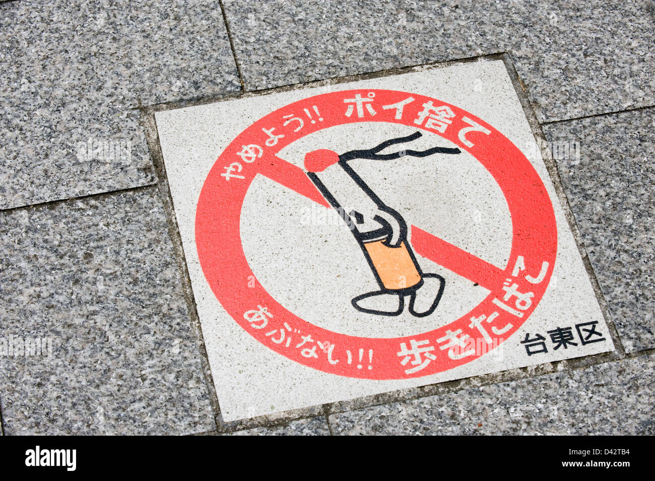 Panneau de trottoir rappelle aux piétons de Taito-ku, Tokyo de ne pas marcher et fumer dans les rues publiques parce que c'est dangereux., Japon. Banque D'Images