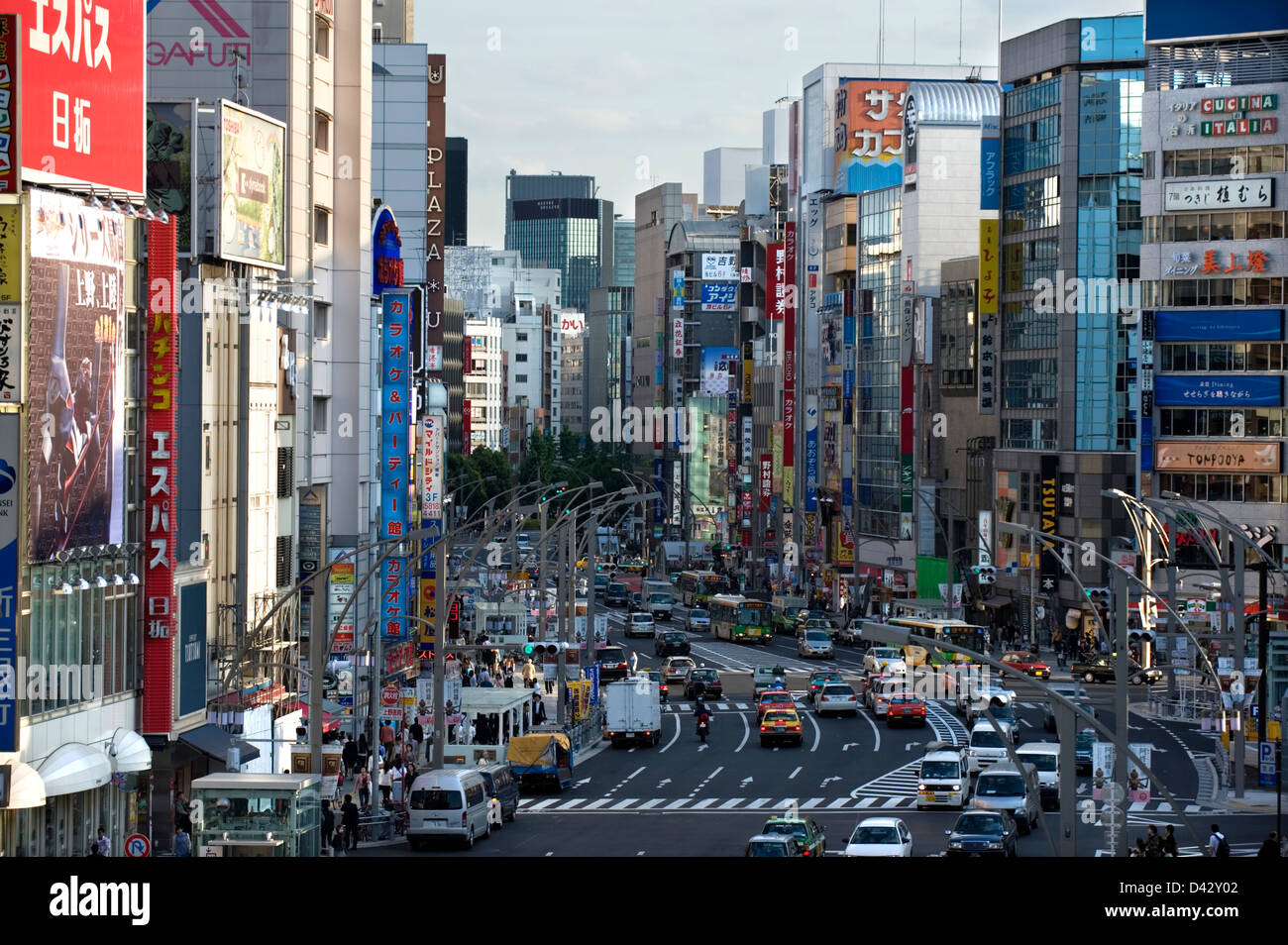 Showa-dori il tisse à travers un canyon de grands immeubles couverts de panneaux publicitaires à Ueno, Tokyo. Banque D'Images