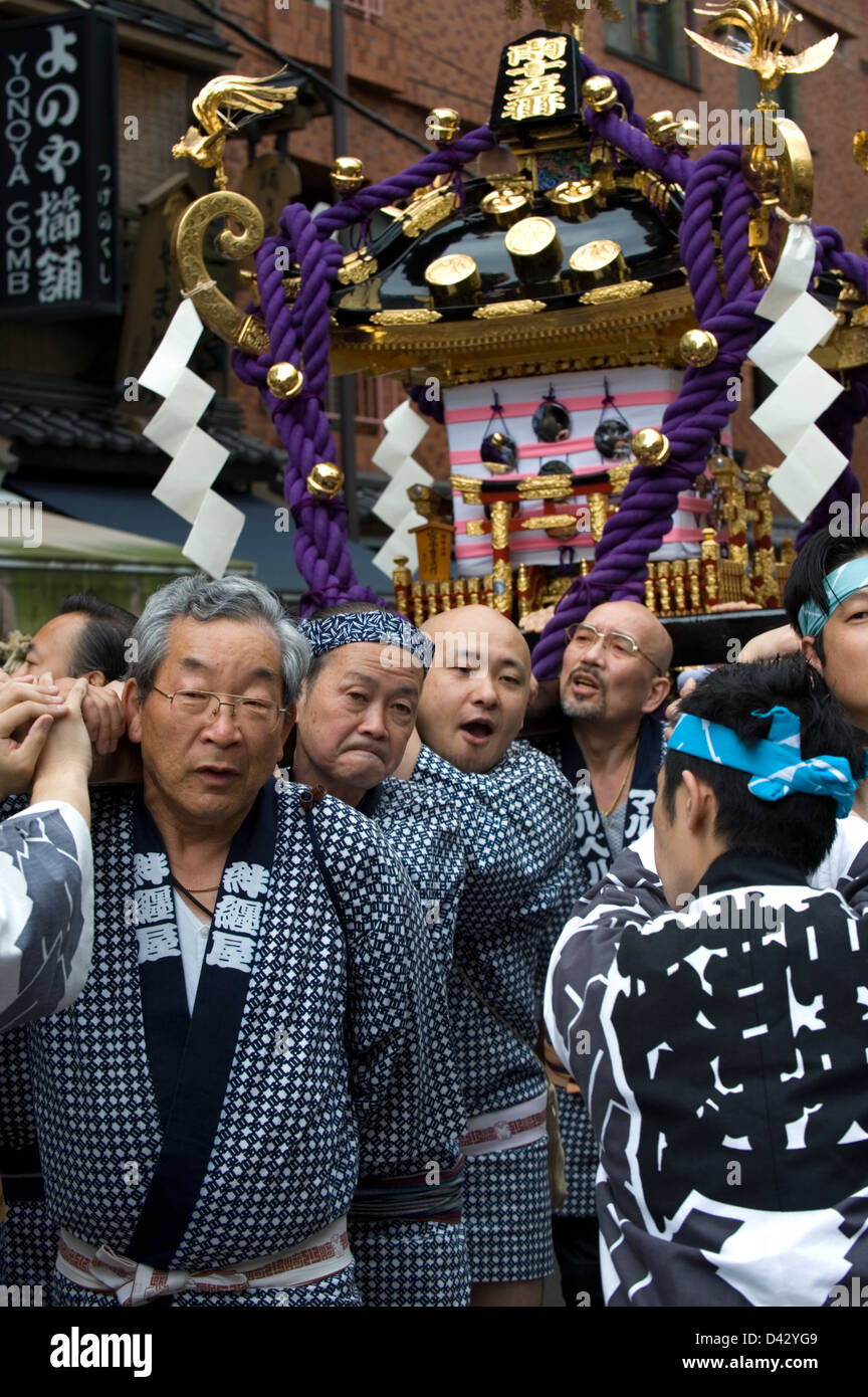 Les hommes portent une décoration or mikoshi sacré sanctuaire portable à Sanja Matsuri Festival, l'un des trois grands festivals de Tokyo Banque D'Images