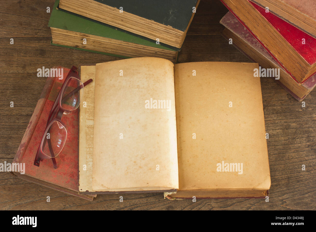 Vieux livre ouvert avec des pages blanches sur fond de bois. Banque D'Images