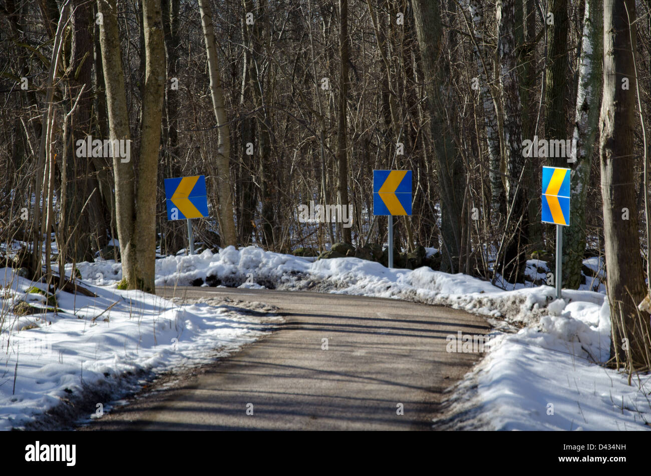 Panneaux dans une courbe à un vélo à l'hiver dans la forêt Banque D'Images