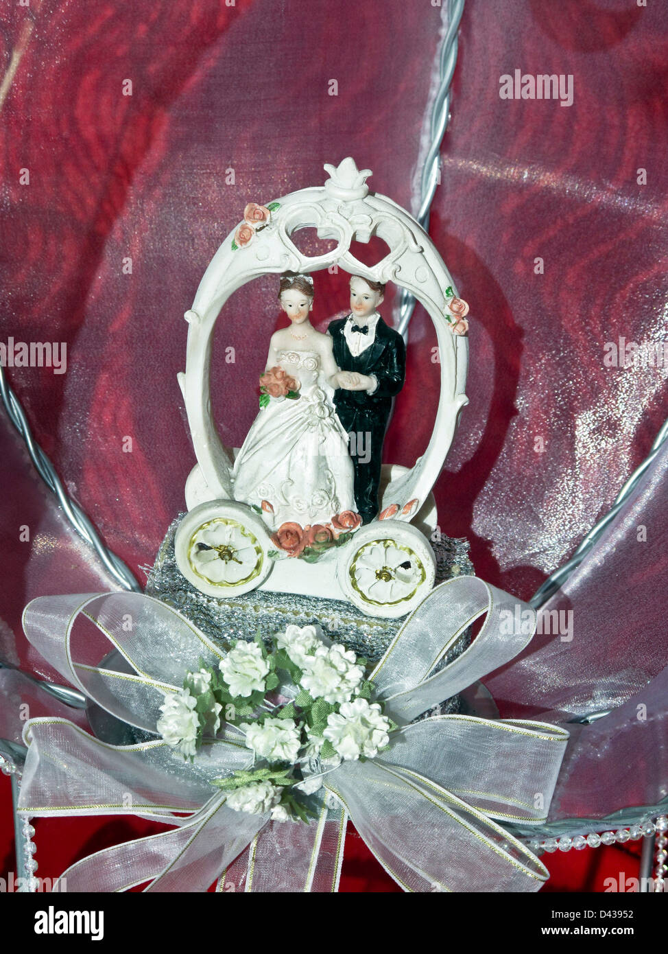 Blushing bride & groom chiffres décorés de roses pour le sommet d'un gâteau de mariage affichée dans la vitrine de l'Oaxaca au Mexique Banque D'Images