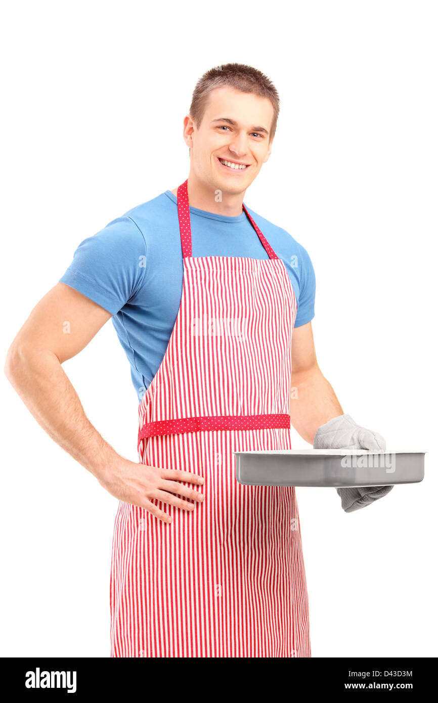 Smiling young man en tablier tenant une cuisson isolé sur fond blanc Banque D'Images