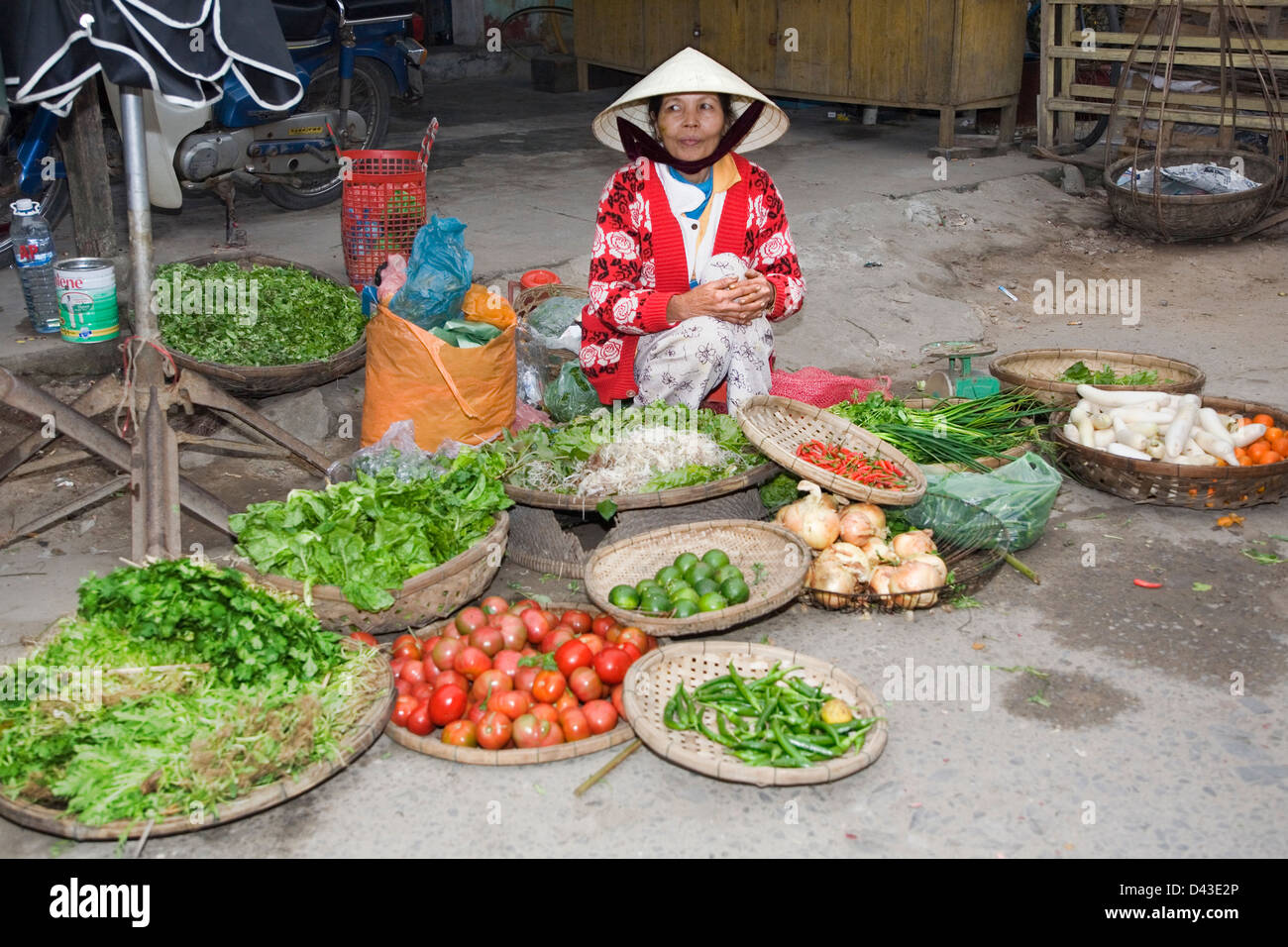 Plus vietnamienne se trouve sur rue avec des paniers de légumes à vendre à Hoi An, Viet Nam Banque D'Images