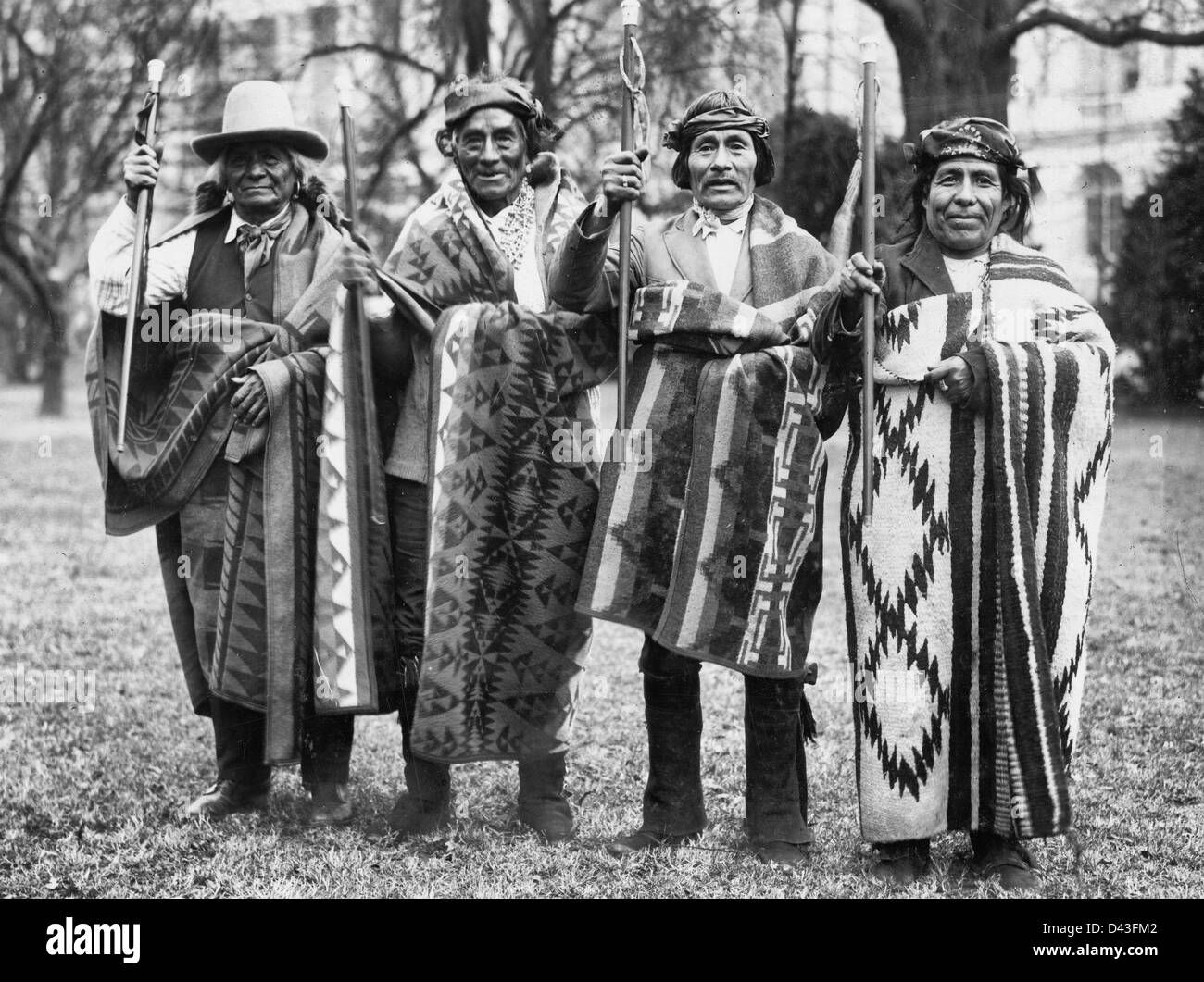 Quatre hommes Pueblo (g à d) Santiago Naranjo, Waihusing, James Miller, et Jésus Baca, debout, face à face, portant des vêtements traditionnels et de l'ouest, chacune portant une couverture et l'exécution d'une canne donné par Abraham Lincoln en signe de promesse de conservation permanente de leurs terres. Banque D'Images