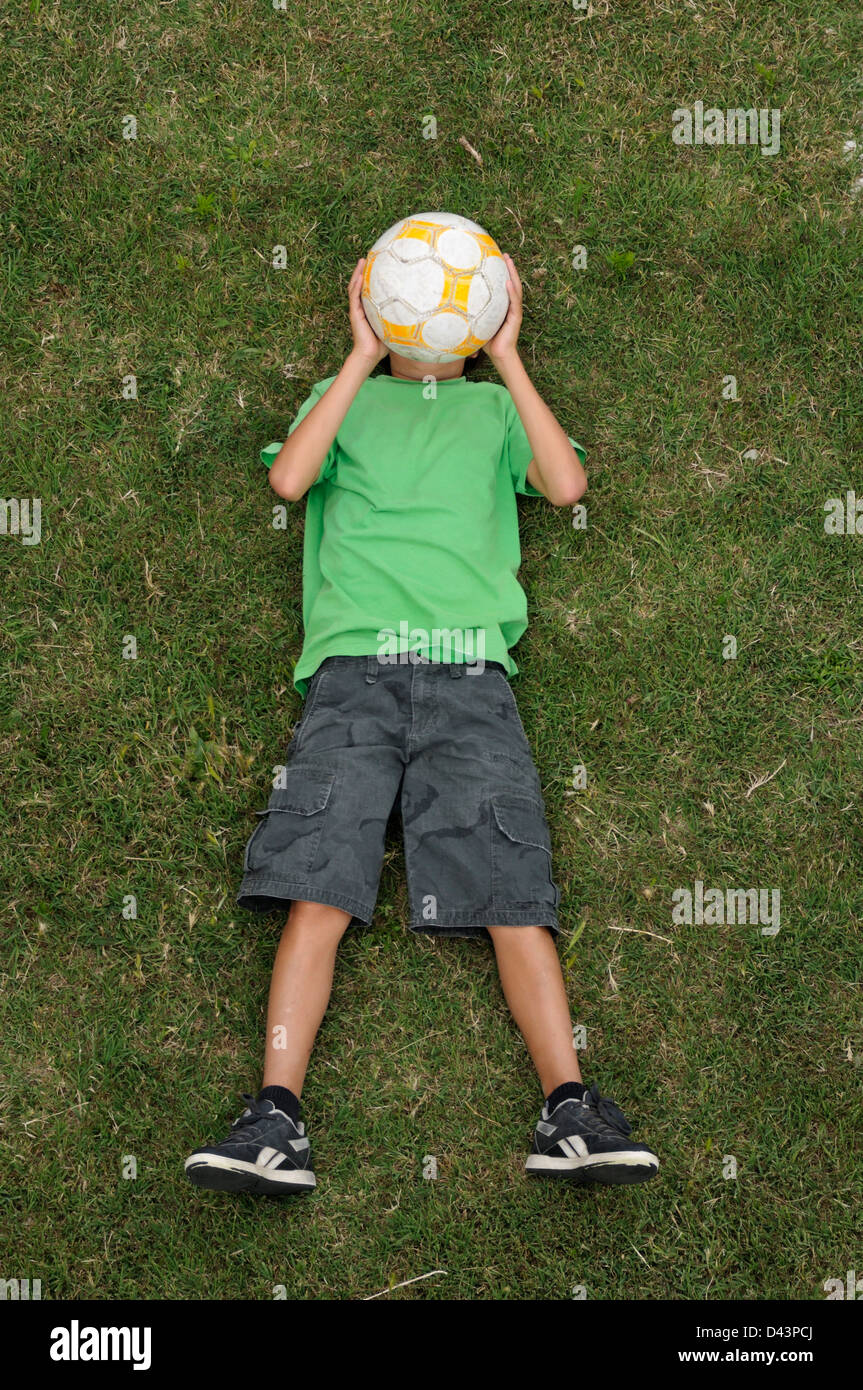 Boy Lying on Grass, Ile de Ré, Poitou-Charentes, France Banque D'Images