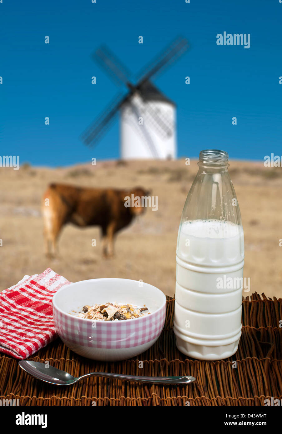 Petit-déjeuner muesli dans une cuillère, Bow et le lait. Vache et moulin sur l'arrière-plan Banque D'Images
