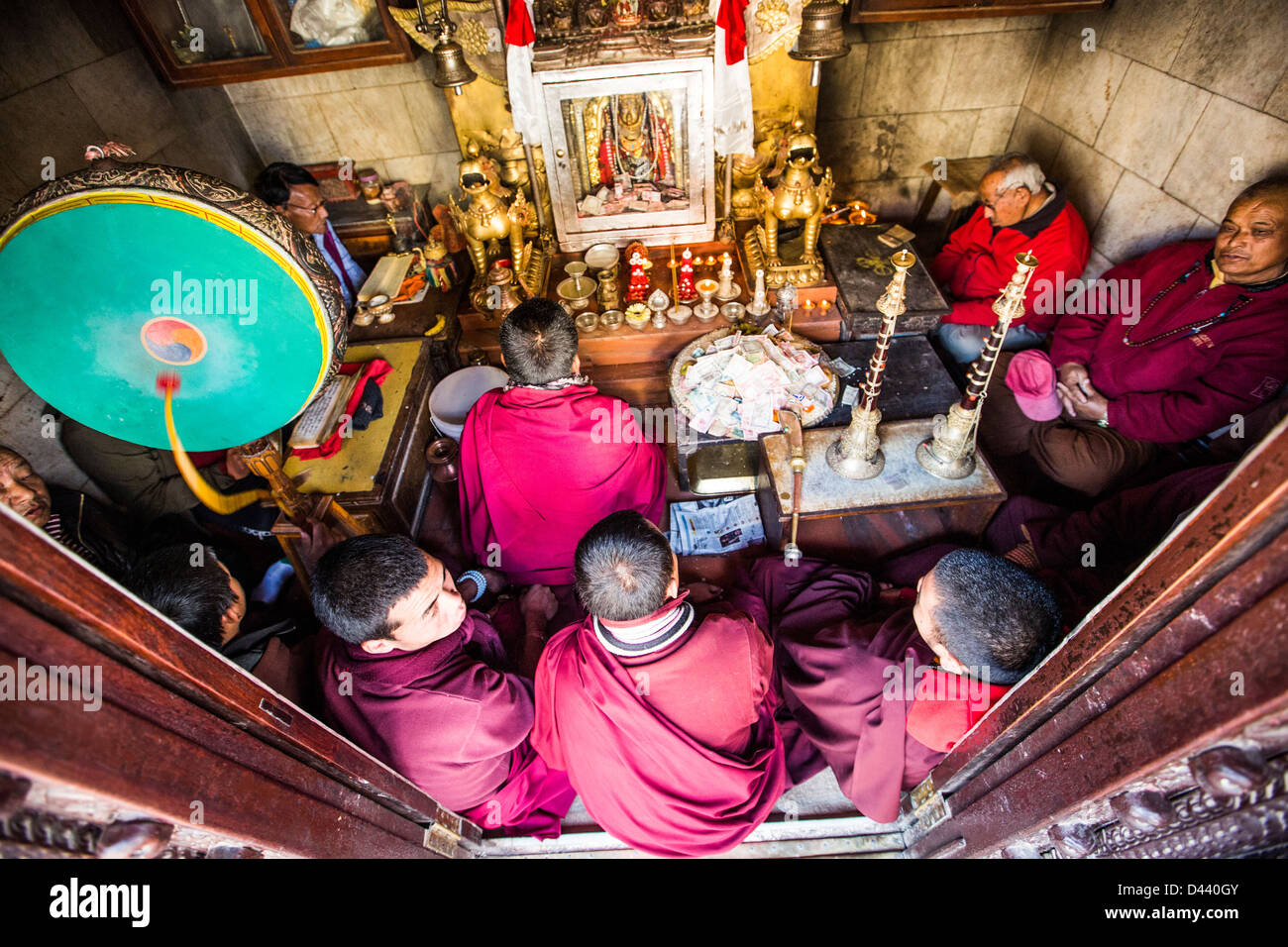 Moines priant dans un hall à praye Stupa Boudhanath, Katmandou, Népal Banque D'Images