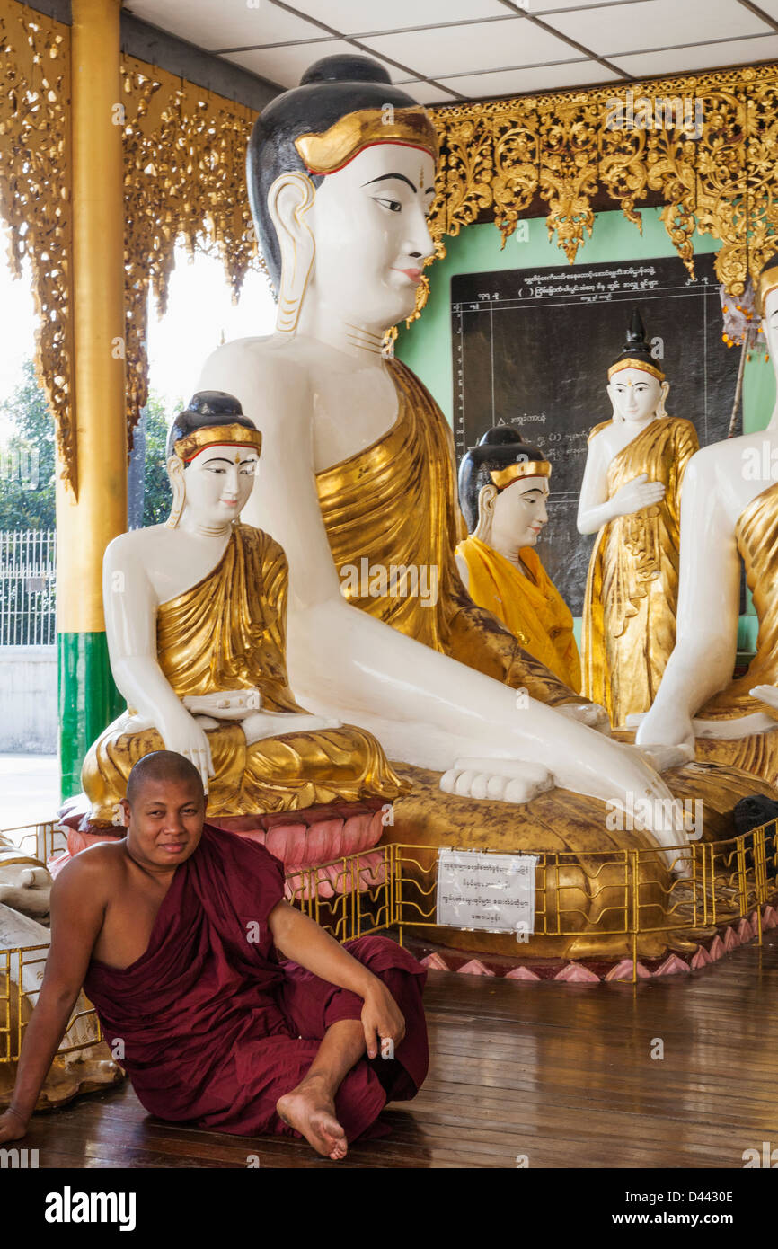 Le Myanmar, Yangon, Shwedagon Pagoda, moine et Statues de Bouddha Banque D'Images