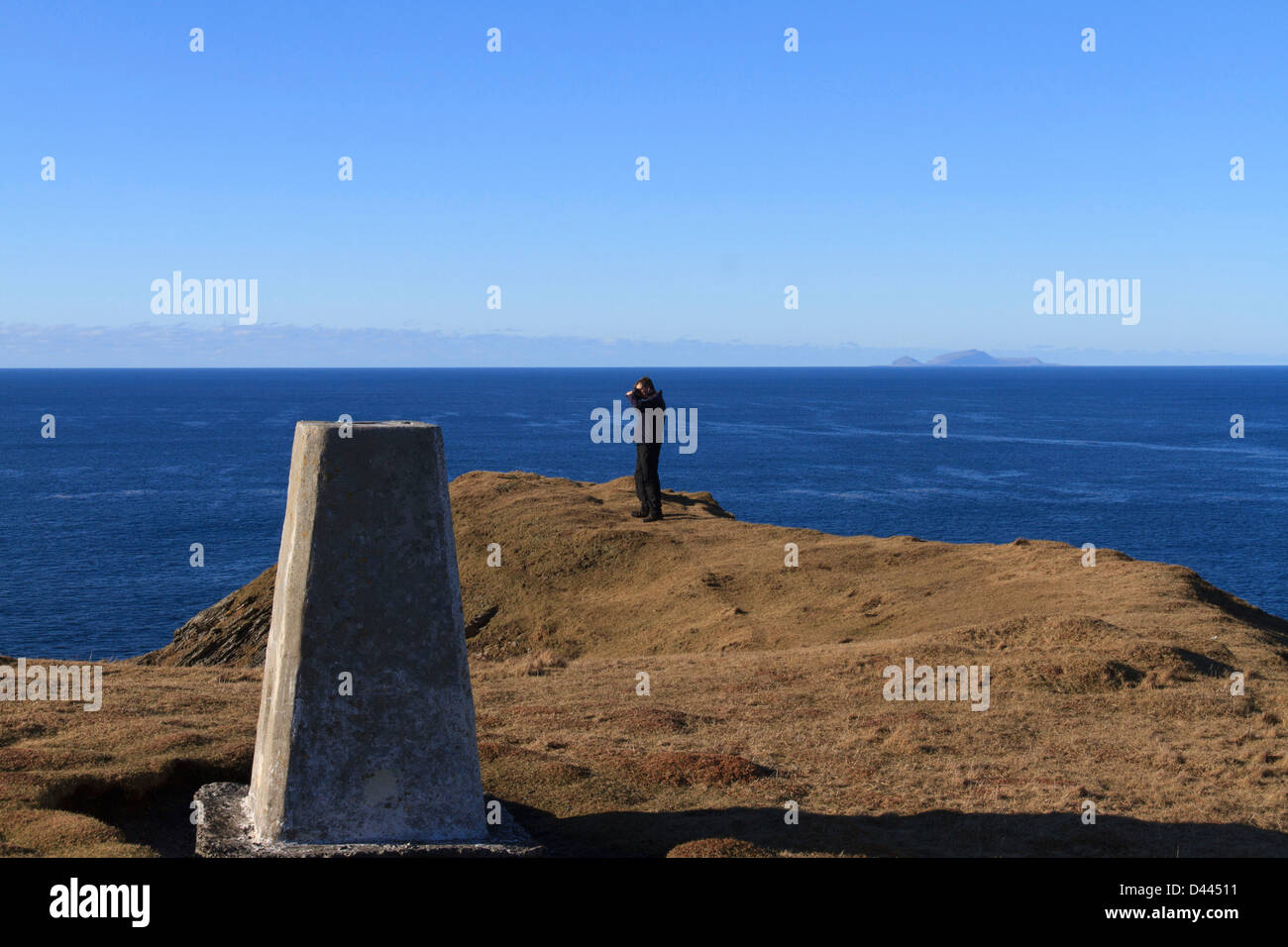 Un homme est photographe de prendre une photo sur le bord de la mer avec un point trigonométrique en premier plan Banque D'Images