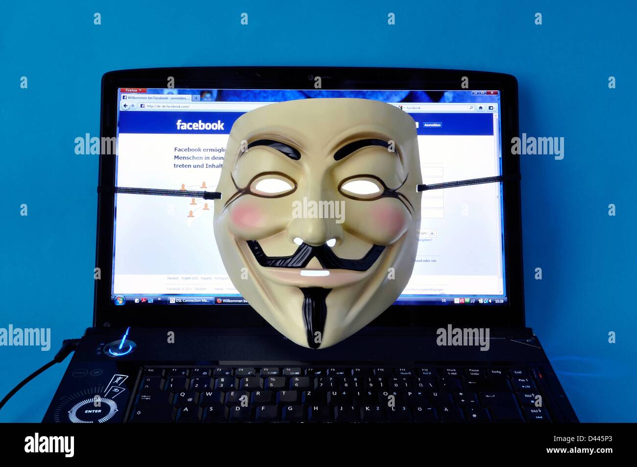 Un masque anonyme (également: Masque Guy Fawkes ou masque Vendetta) est représenté sur un ordinateur portable, qui affiche la page Internet Facebook en 2011. Fotoarchiv für ZeitgeschichteS.Steinach Banque D'Images