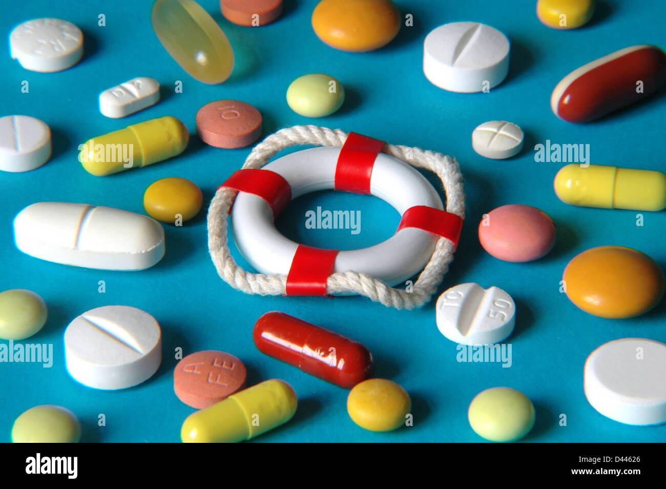 Illustration - plusieurs comprimés et capsules colorés sont répartis autour d'une bouée de sécurité miniature, à Berlin, en Allemagne, le 25 décembre 2007. Fotoarchiv für ZeitgeschichteS.Steinach Banque D'Images