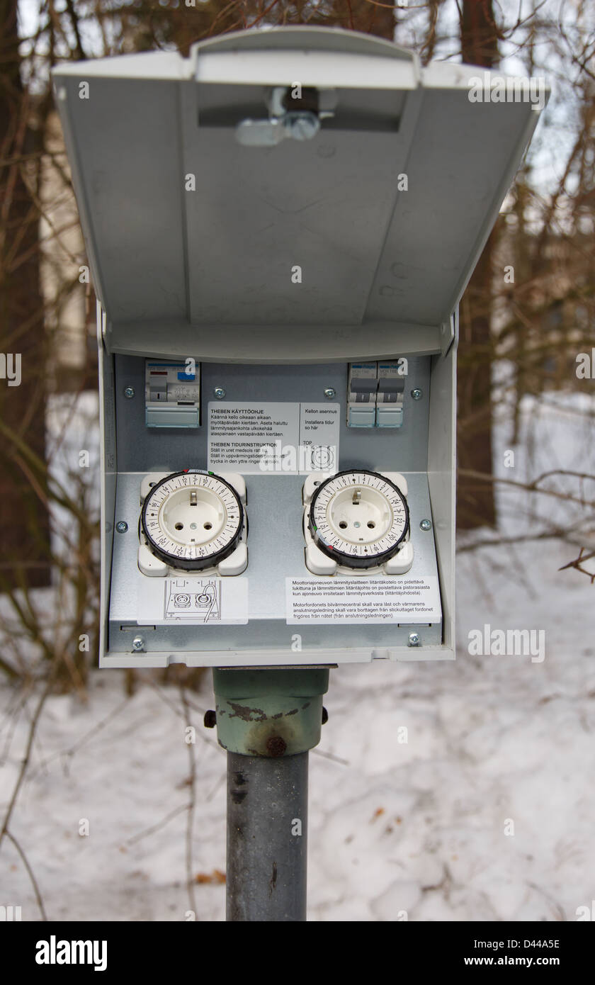 Stationnement avec prise électrique 220 V AC sockets pour chauffe-bloc moteur de voiture utilisé par temps froid les températures d'hiver de Finlande. Banque D'Images