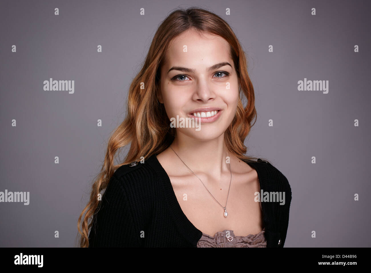 Happy young woman smiling at camera, portrait. Banque D'Images