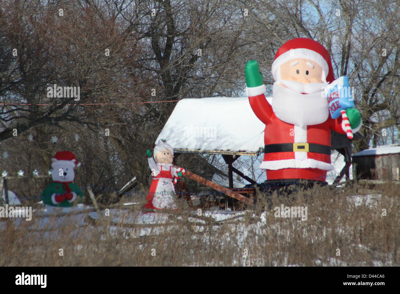 Affichage de triage Blowup Santa Clause dans un champ ouvert avec une couche de neige au sol Banque D'Images