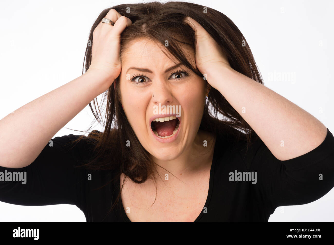 Une jeune femme en colère en criant, déchirant ses cheveux brun , Royaume-Uni Banque D'Images