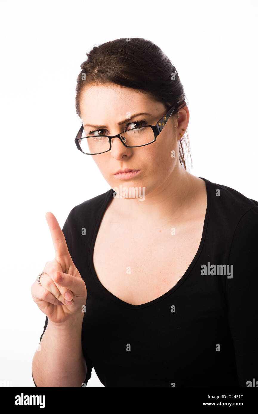 Une jeune femme à l'arrière, les cheveux bruns, portant des lunettes lunettes pointant son doigt UK Banque D'Images