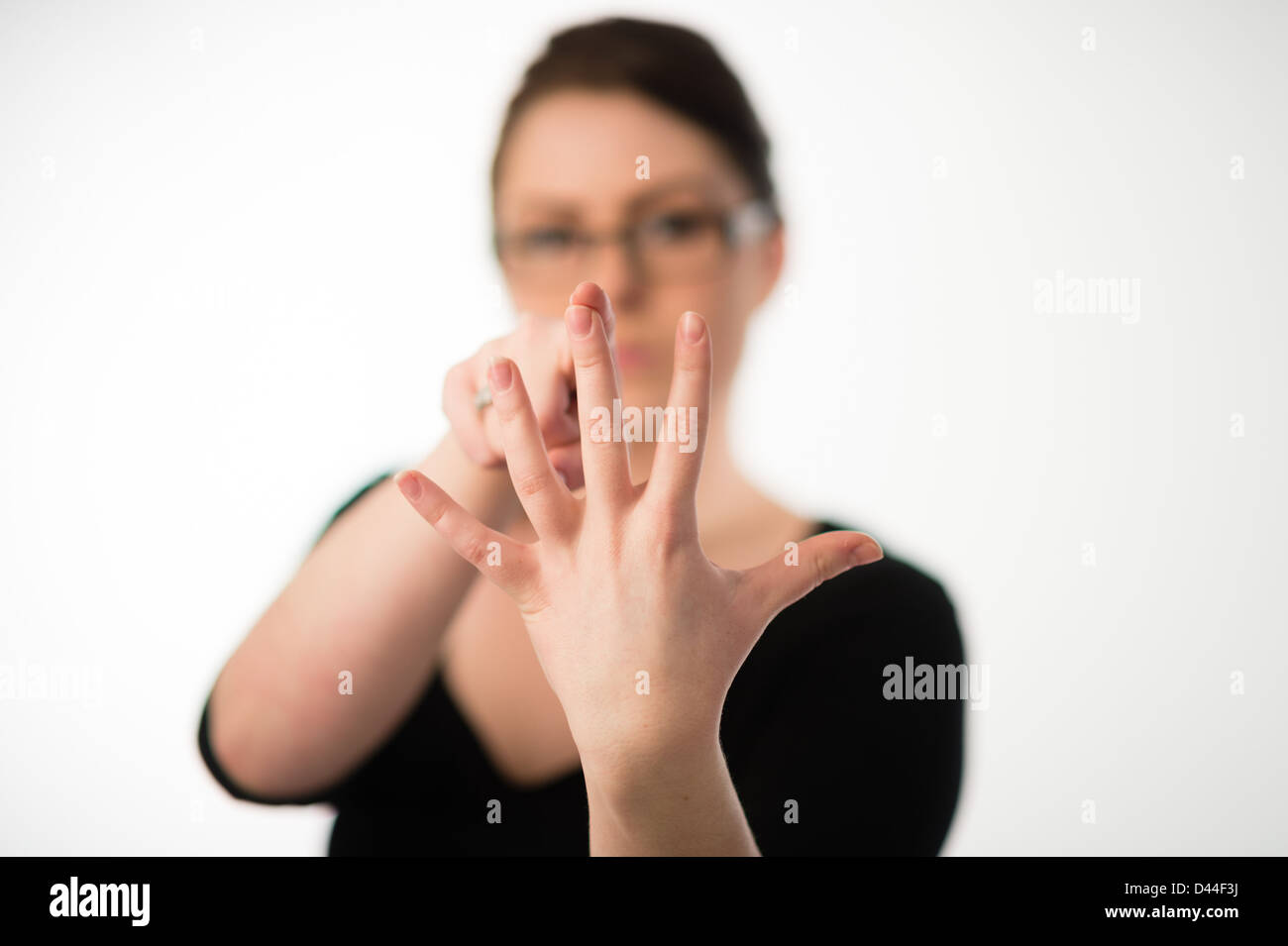 Une jeune femme, les cheveux bruns, compter jusqu'à cinq 5 sur les doigts de sa main, UK Banque D'Images