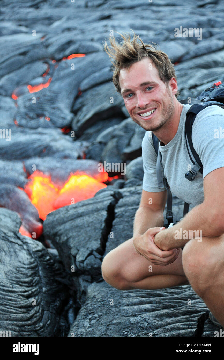 Portrait of happy young Caucasian hiker voir lave du volcan Kilauea à Hawaii Volcanoes National Park, États-Unis Banque D'Images