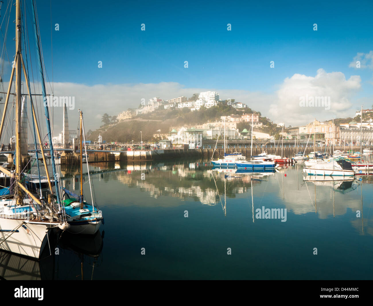 Vue sur le port de Torquay sur un lumineux matin, encore, avec sea mist enveloppant les bâtiments. Banque D'Images