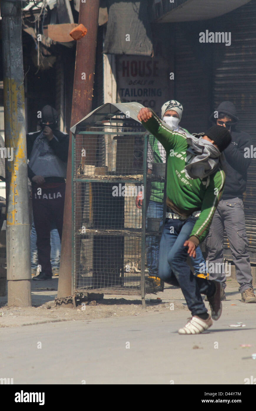 5 mars 2013 - Srinagar, au Cachemire, en Inde - un manifestant lance des pierres sur du Cachemire policiers indiens lors d'un affrontement entre les manifestants et la police indienne à Srinagar, la capitale d'été du Cachemire indien. La vie normale a été frappé pour la deuxième journée consécutive, aujourd'hui, grâce à une marche organisée par un groupe de séparatistes à la résidence d'un étudiant du Cachemire, qui a été retrouvé pendu dans sa chambre à l'auberge à Hyderabad. Les autorités ont déployé du personnel de police et paramilitaires en grand nombre dans le sud du Cachemire Pulwama ville, la région de Mudasir Kamran, (25) qui a été retrouvé pendu au plafond de son hôte Banque D'Images