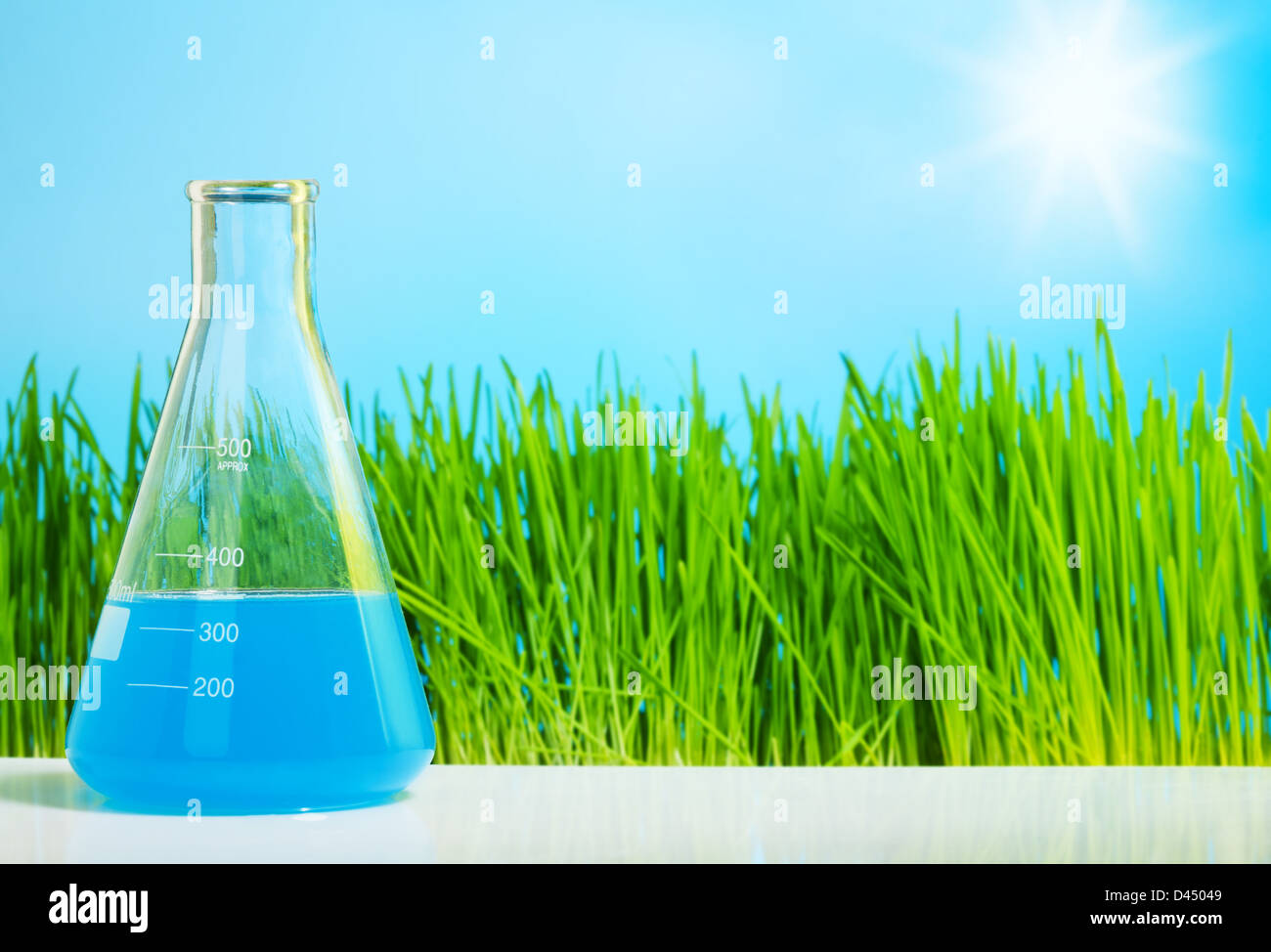 La fiole avec un liquide bleu sur fond d'herbe verte Banque D'Images