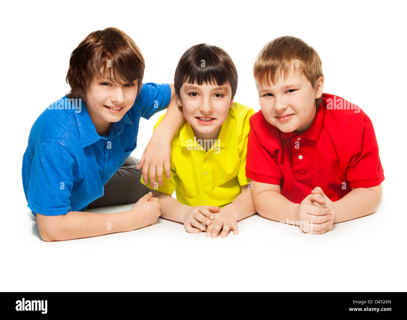 Trois collégiens fixant ensemble sur le plancher, souriant, l'air heureux, et sortit, isolé sur whtie Banque D'Images