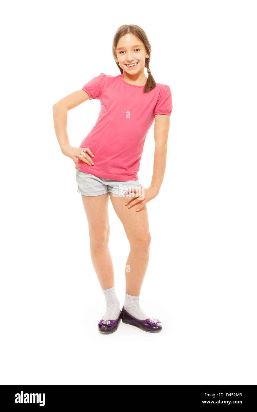 Portrait of cute, souriant, heureux 9 ans girl with ponytails, isolé sur blanc avec les mains sur les hanches Banque D'Images