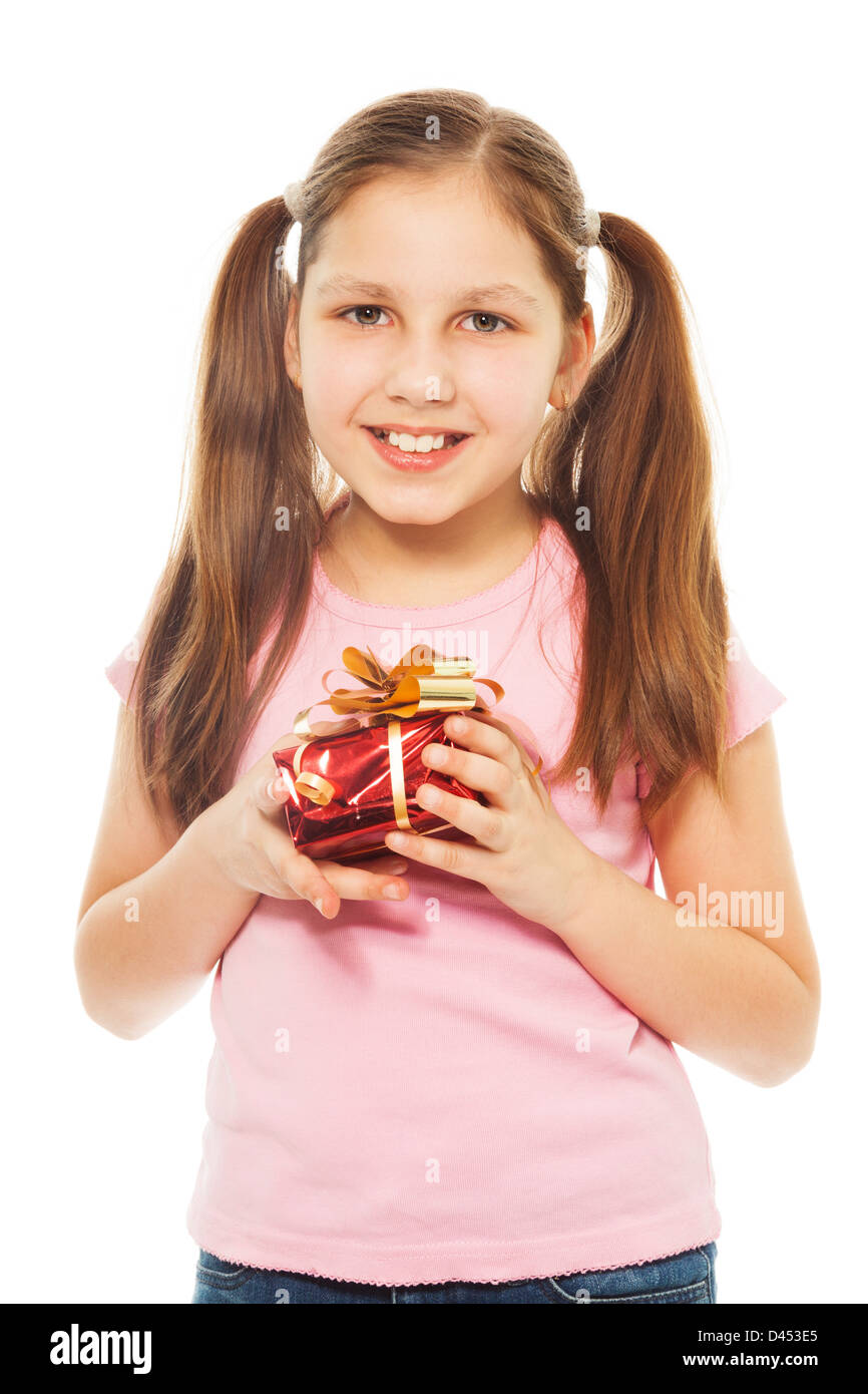 Happy teen Caucasian girl with ponytails holding petit rouge présent fort avec de l'or avec sourire sur son visage, isolé sur blanc Banque D'Images