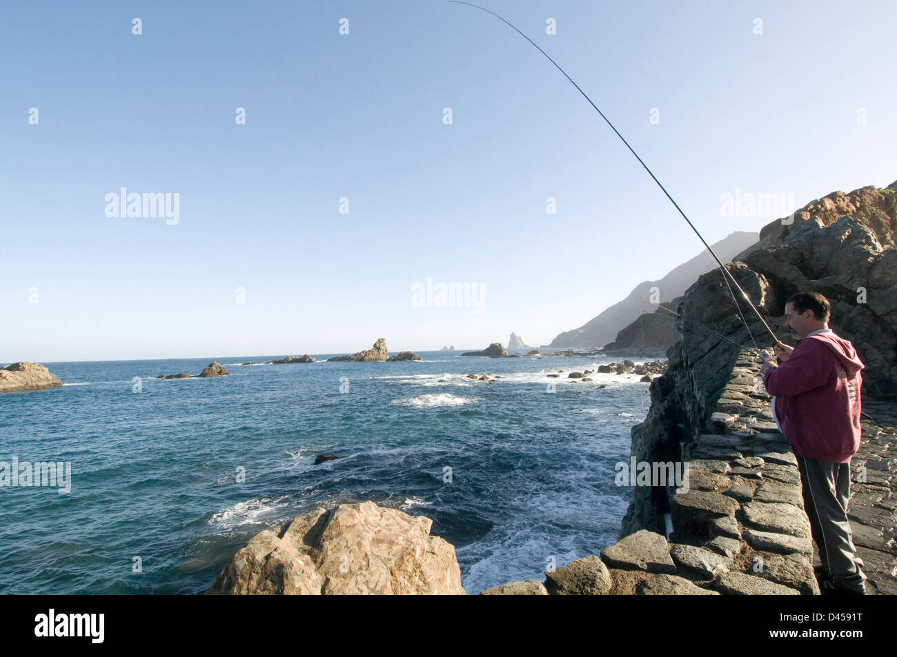 Les tiges de canne à pêche pêcheur homme homme hommes attraper du poisson capturé line tenerife isles canaries mer bleu ciel ciel mer Banque D'Images