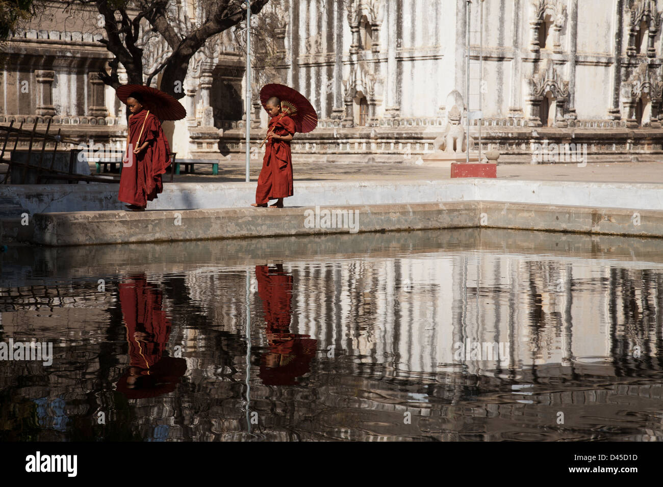 Deux moines marcher a adopté un plan d'eau au Temple Ananda Pahto, Bagan. Banque D'Images