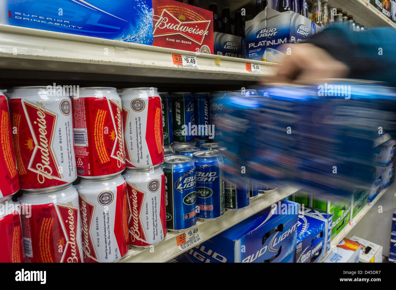 Un nouveau client s'empare de canettes de bière Budweiser par le brasseur Anheuser-Busch InBev dans un supermarché de New York Banque D'Images