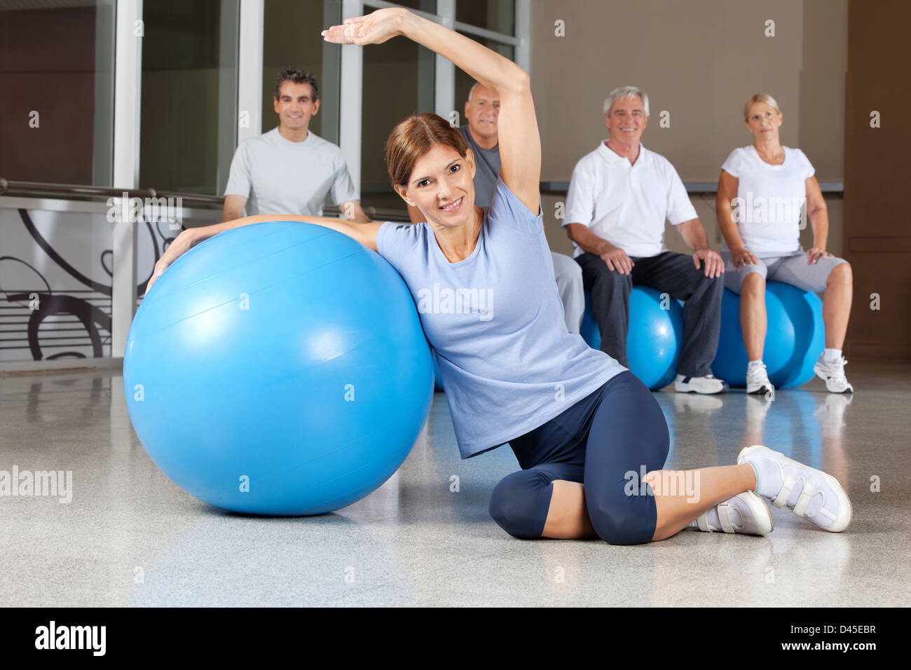 Happy woman retour exercices avec ballon bleu en centre de remise en forme Banque D'Images