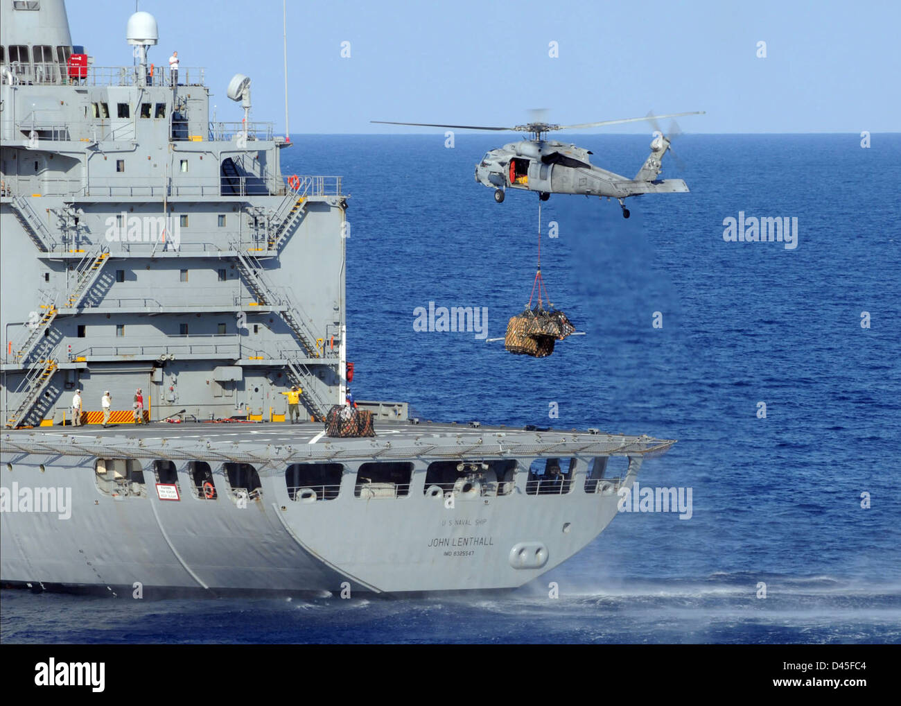 Un hélicoptère MH-60S Seahawk récupère du ravitaillement sur un navire de la marine lors d'une opération de réapprovisionnement dans le canal de Suez. Banque D'Images