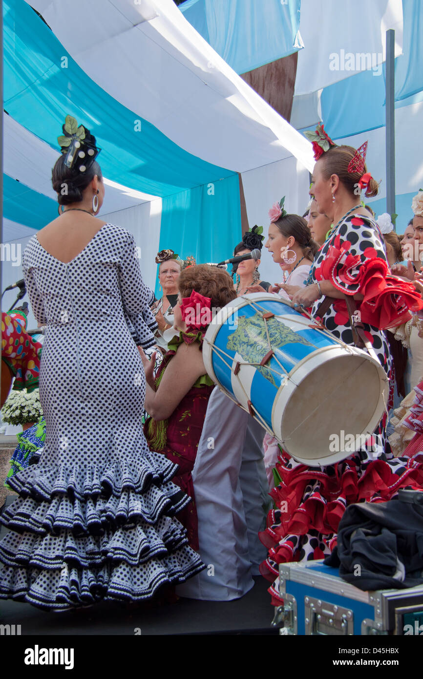 Choeur de femmes portant des robes de flamenco traditionnel dans un procès équitable, en Andalousie. Banque D'Images