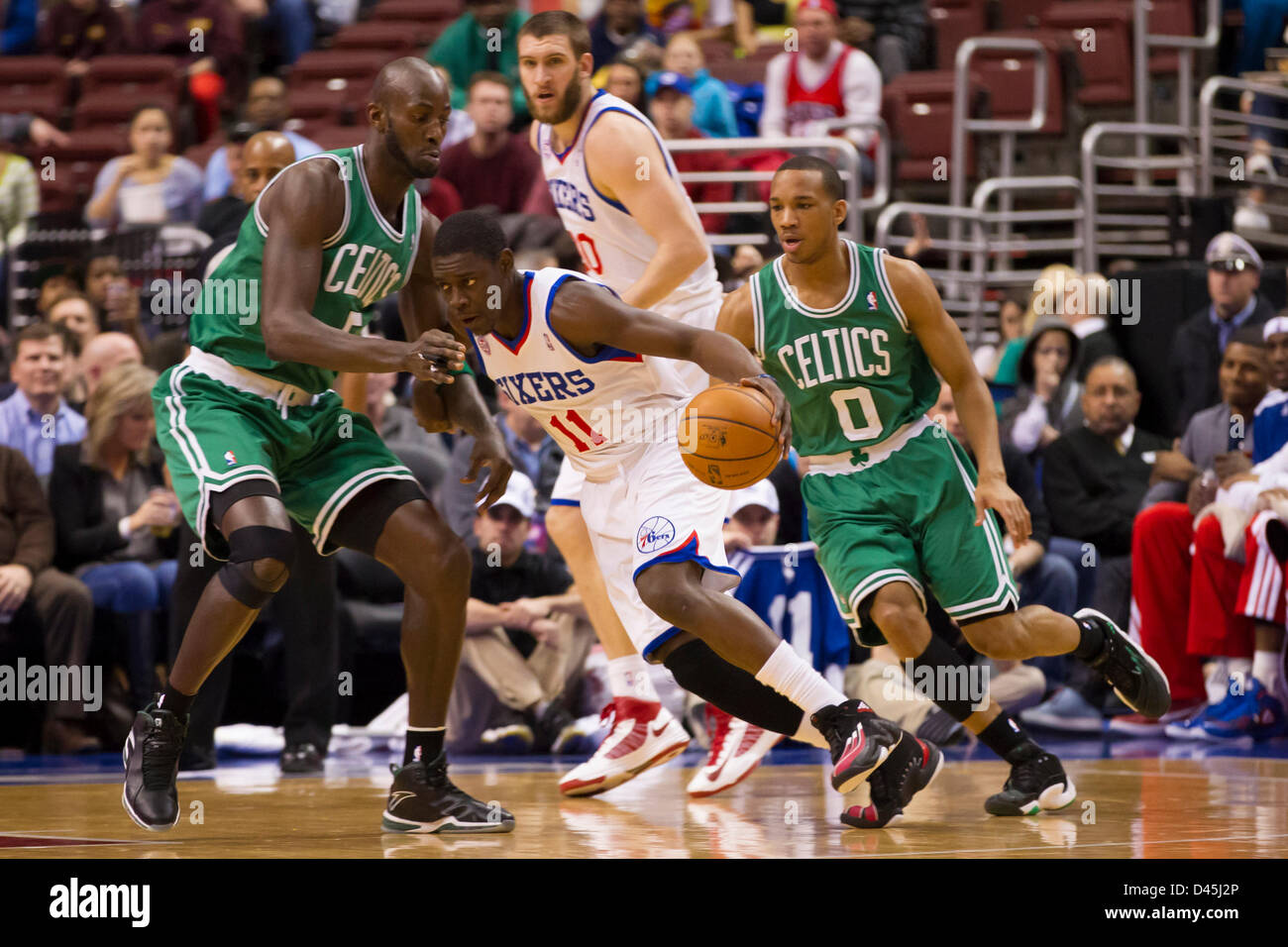 Philadelphia, États-Unis. 5 mars 2013 : Philadelphia 76ers point guard Jrue Holiday (11) en action avec la balle comme il est flanqué de Boston Celtics Kevin Garnett centre (5) et le point guard Avery Bradley (0) avec les Philadelphia 76ers center Spencer HAWES (00) à la recherche sur le jeu au cours de la NBA entre les Boston Celtics et les Philadelphia 76ers au Wells Fargo Center de Philadelphie, Pennsylvanie. Banque D'Images