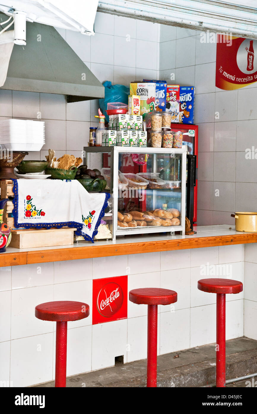 Snack-bar attrayant immaculée avec comptoir repas poterie de Oaxaca et textile à côté d'aliments emballés & Coca Cola Mexique Oaxaca Banque D'Images